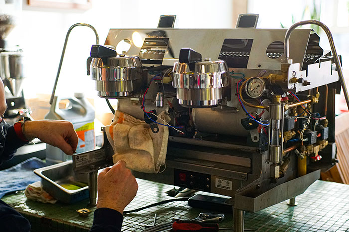 Coffee machine technician repairing espresso machine in Morningside